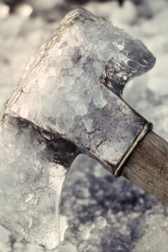 A close-up shot of an ice axe lying on a pile of ice. vertical frame