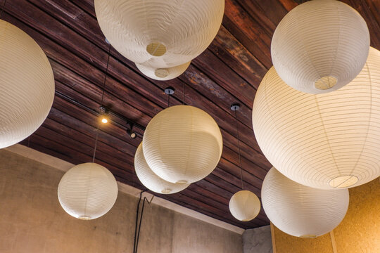 Traditional Asian white paper lantern on the ceiling in living room at home,detail of white Japanese Paper lamps,mediterranean design,home interiors,cozy house,Space for text.