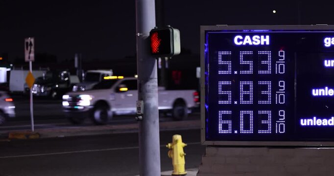 High gas prices display on a board at a gas station on a city street.