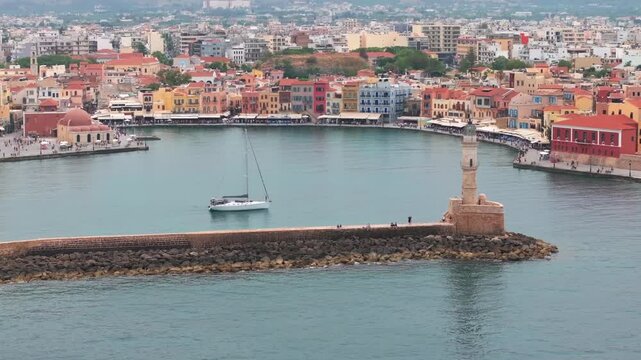  View of Chania with the amazing lighthouse, mosque, venetian shipyards, Crete, Greece.Waves crashing on lighthouse, Beautiful Greece and best scenic places - panorama