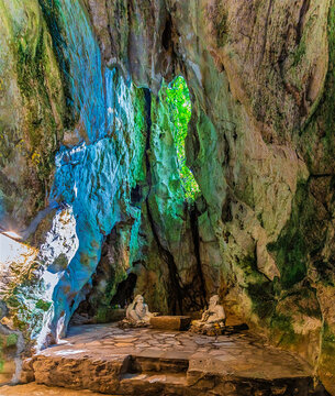 An interior view of a cave with stone statues, located within the Marble Mountains in Da Nang, Vietnam on a bright sunny day