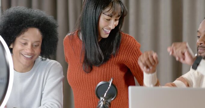 Diverse hosts on set cam starting waving orange reaching ring checking laptop hugging celebrating