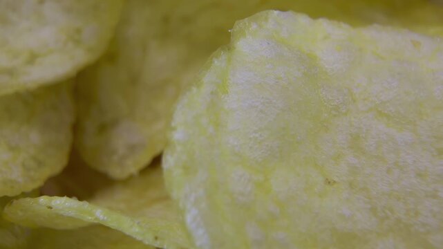Macro close-up of crispy potato chip surface with oil blisters