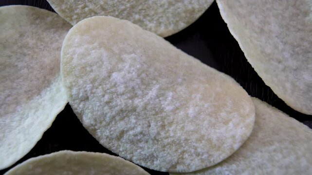 Potato chips rotating in macro view with textured surface