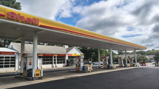 Chantilly, Virginia, USA &ndash; September 13, 2026: A Shell gas station under a cloudy sky. The image shows a long yellow canopy, fuel pumps, and a service center building with oil-change bays.