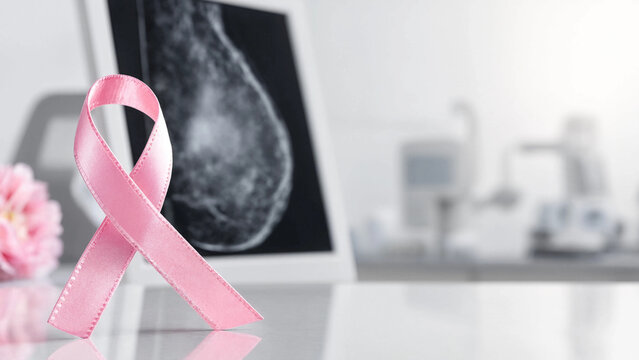 Pink awareness ribbon in front of a mammogram x-ray image in hospital with x ray