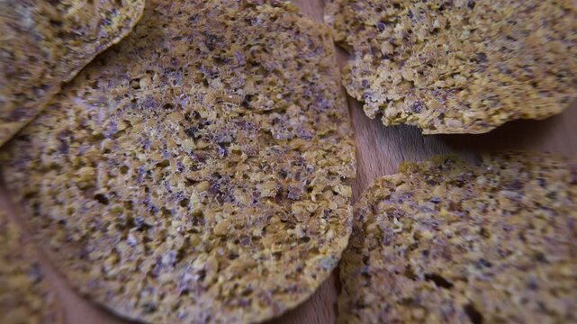 Dehydrated Fruit and Seed Cracker Surface Rotating on Wood, Macro