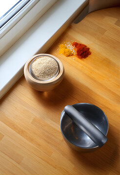 Healthy nutrition and organic cooking, quinoa seeds in wooden bowl with spices and metal mortar on kitchen countertop for culinary preparation and diet
