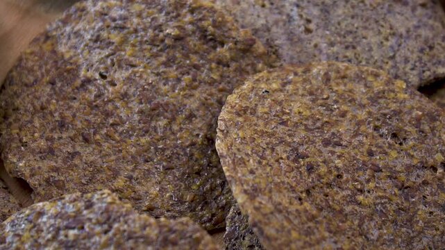 Close-up of raw fruit and seed crackers rotating with shallow depth of field