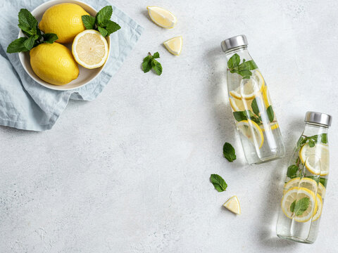 Young woman preparing fresh lemonade in a bright kitchen with copy space
