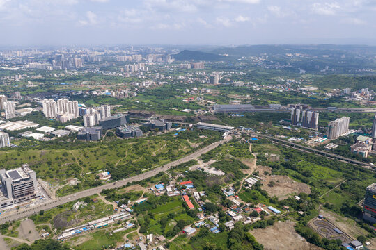 Aerial view of Hinjewadi Phase III featuring modern office buildings surrounded by lush green landscape and road infrastructure in Pune, Maharashtra, India.