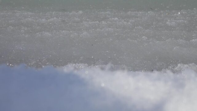 Cream ice, ice fat on Azov Sea. In calm, frosty weather, even salt water freezes, pancake ice forms, The waves knock the ice into white frozen stripes on the shore, the white foam and sand hardens