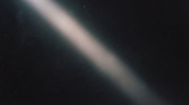 Diagonal beam of light on dark background with dust particles