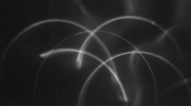 Abstract light trails forming curved arches on a dark background