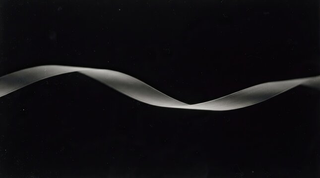 Abstract flowing white ribbon shape on a solid black background