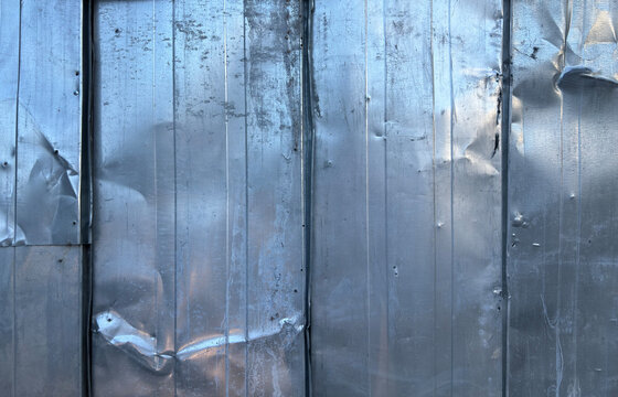 Dentated metal sheet texture. Distressed metallic fence background
