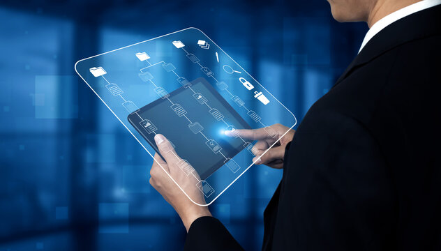 Business Professional Using Touchscreen Tablet with Digital Interface Icons in Modern Office Environment. Sentient.