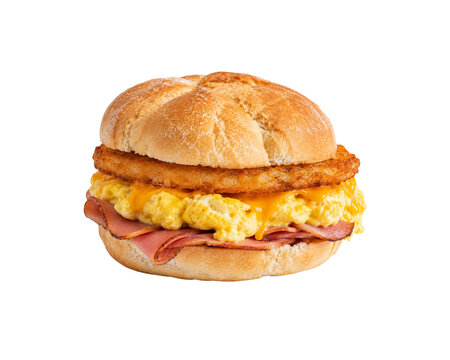 Ham egg cheese and hashbrown breakfast sandwich on a kaiser roll isolated on black background