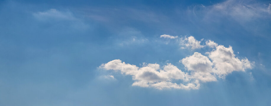 Blue sky with white clouds and sunbeams in daytime