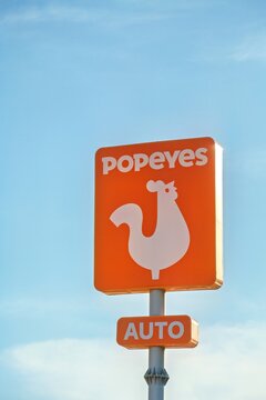 La Nucia, Spain - September 4, 2026: Popeyes logo sign on pole with blue sky background. Popeyes Louisiana Kitchen is American multinational chain of fried chicken fast food restaurants