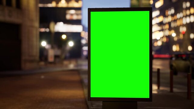City billboard with a green screen placed on a metropolitan street late at night under street lamps, wet streets after rain. Timelapse footage with blurred traffic and city lights, ideal as a template