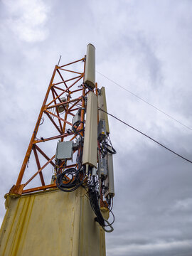 Telecommunications Tower with Antennas Against Cloudy Sky