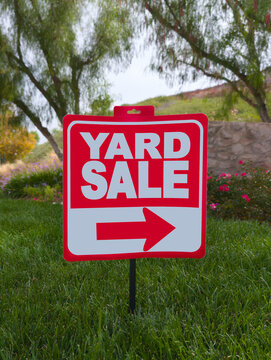Yard Sale Sign with Direction Arrow on Residential Lawn