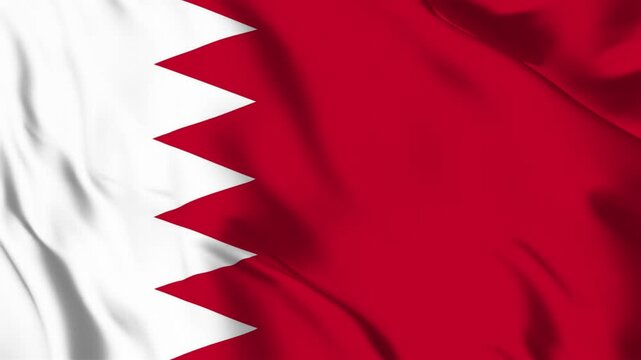 The national flag of Bahrain featuring a white serrated band on the left and a red field on the right waving in the wind