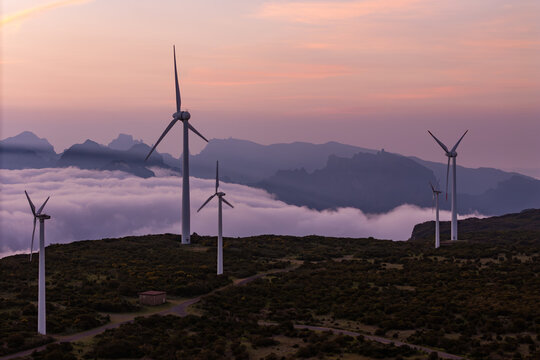 Wind turbines on elevated terrain above cloud cover in Madeira, decarbonization and energy transition concept