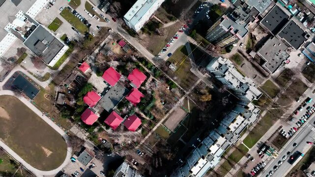 Residential neighborhood in overhead drone view with apartments, courtyards and railway tracks. Urban planning, real estate, amenities and transport connectivity