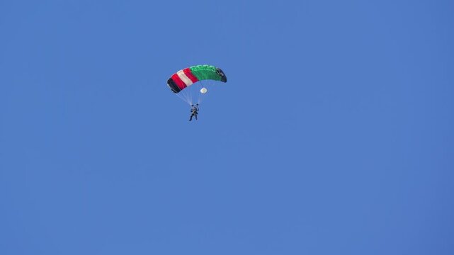 Parachutist with flag parachute descending