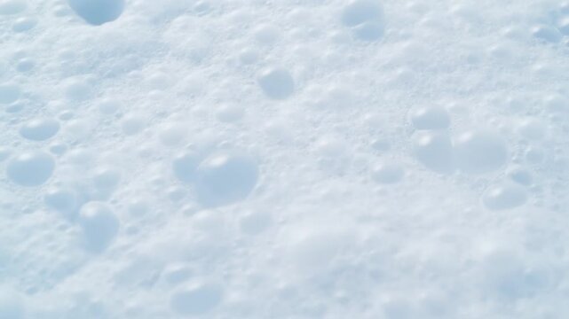 Snowcovered surface with soft blue shadows and textured white winter detail