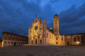 Obraz premium The illuminated Siena Cathedral Santa Maria Assunta (Duomo di Siena) in blue hours Tuscany, Italy.