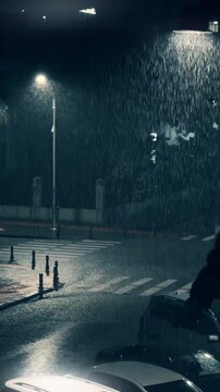 Night rain over dark street, with rainfall under streetlights and reflections on wet asphalt creating cinematic urban ambience. Vertical video.