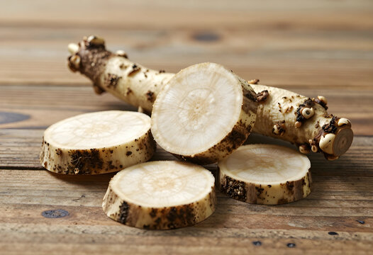 Horseradish root and slices, healthy nutrition and organic food concept, fresh spicy vegetable ingredient for culinary recipes on a rustic wooden table