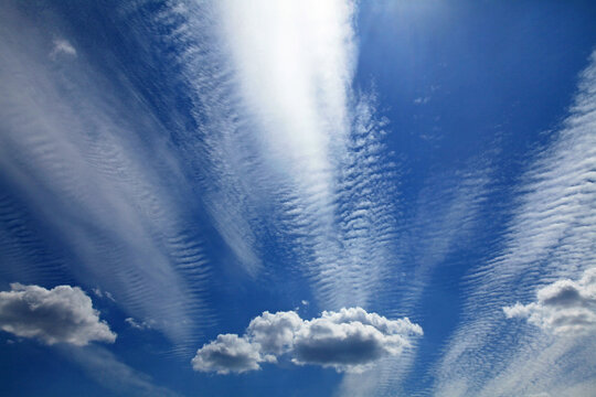 Cirrus, stratus and cumulus clouds in the same sky. Multilayer clouds pattern. Skies landscape in summer. High clouds in the backlight of the sun. Cloud layer. Clouds, atmosphere and weather formation