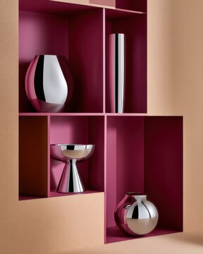 Modern minimalist interior shelf with metallic vases and pink burgundy cubbies for design background poster and home decor styling