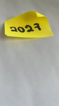 Yellow sticky note with 2027 handwritten and blank copy space