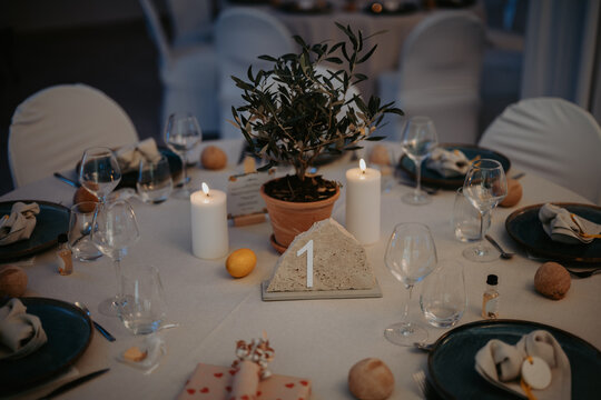 Table de r&eacute;ception &eacute;l&eacute;gamment dress&eacute;e avec agrumes, assiettes bleu nuit et d&eacute;coration lumineuse
