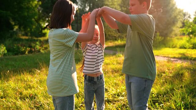 Happy children playing playground, children hands sun glare nature, boy girl friends playground, group of children laughing and playing a hand game, weekend outdoor fun for kids in nature, lively