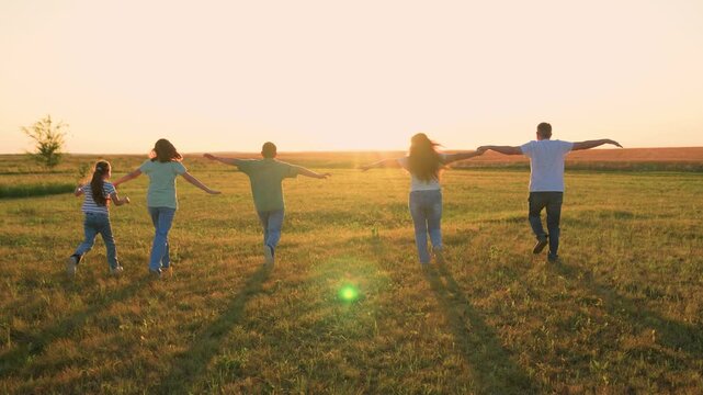 Mother father child kid run green meadow sunset, happy family, silhouette cheerful team group people, generational joy running free over meadow under setting sun together., they follow the light