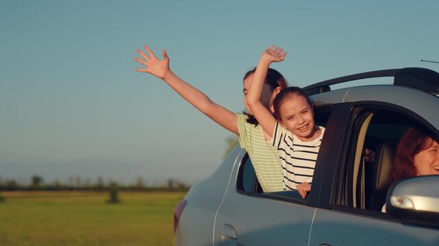 Woman mother child driving car, kid boy girl waving their hands out car window, happy family cheerful people childhood, roadside adventure snapshot of family joy and open horizons ahead, summer road