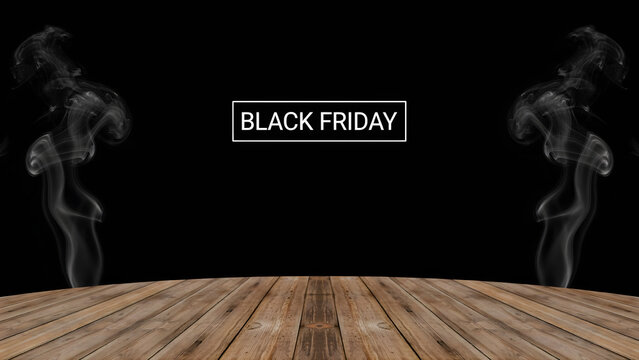Black friday promotional sign with white text in a frame, surrounded by rising smoke on a wooden table surface against a black background