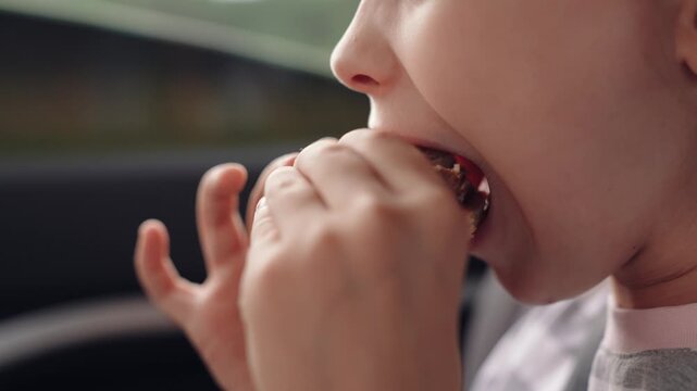 little girl child eating burger in car, happy person, Satisfying road hunger, fast food happiness, stripe-shirt girl, car seat munching, travel experience, burger love, little explorer, meal with a