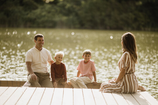 Joyful family moments by the serene lakeside in the warm afternoon light