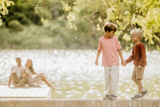 Two playful boys enjoy a joyful moment by the lake on a sunny day