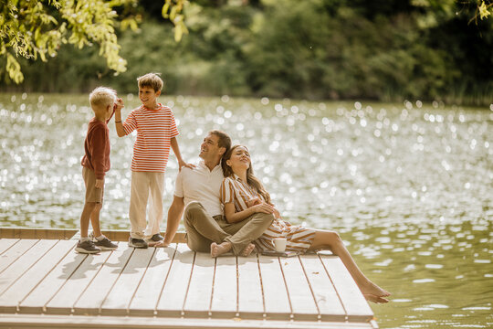 Family bonding on a peaceful lakeside deck during a sunny afternoon