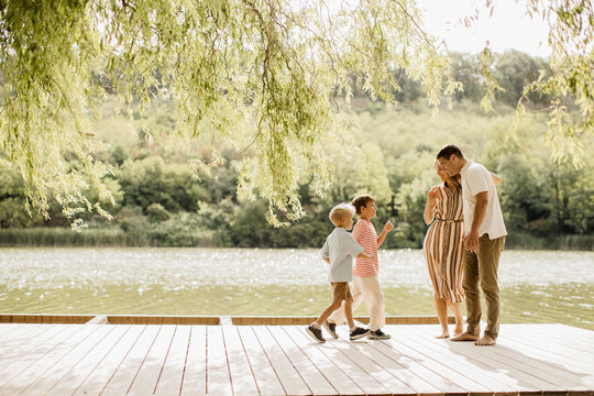 Joyful family moments during a sunny day by the serene lakeshore