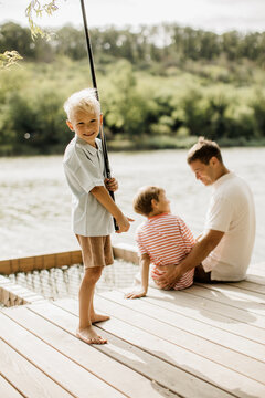 Joyful moments at the lakeside as children enjoy fishing with a parent