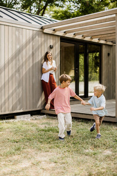 Children joyful in play outside a modern home on a sunny day
